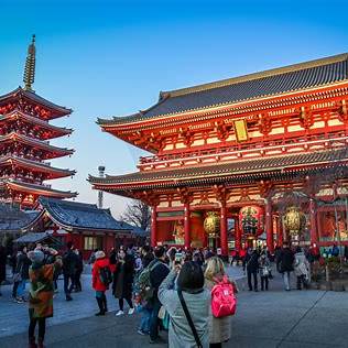 Tourists visiting Senso-ji Temple in Asakusa, Tokyo, with the iconic red gate and five-story pagoda