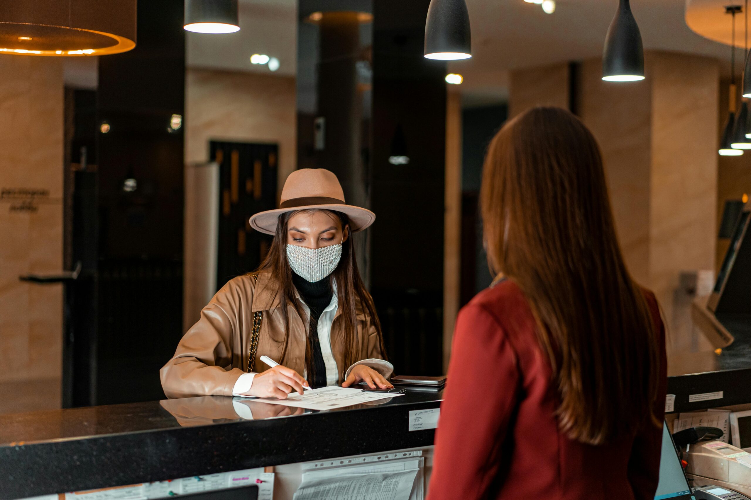 Traveler checking in at a hotel front desk with staff assistance, representing multilingual support in Japan