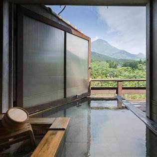 Private open-air onsen at a ryokan in Yufuin with a scenic view of Mount Yufu