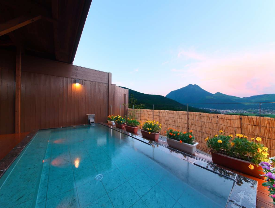 Outdoor hot spring bath surrounded by nature at a Yufuin ryokan